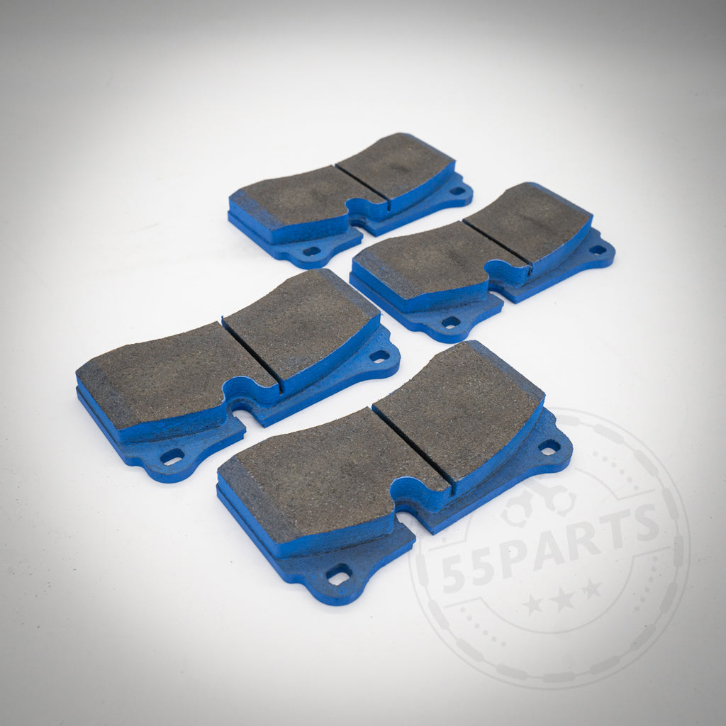 Vier blaue und graue Endless Bremsbeläge für 4-Kolben BMW (Performance) Sattel, passend für BMW M2C Hinterachse (Große Bremse), sind auf einer weißen Fläche angeordnet – ideal für überlegene Bremsleistung.