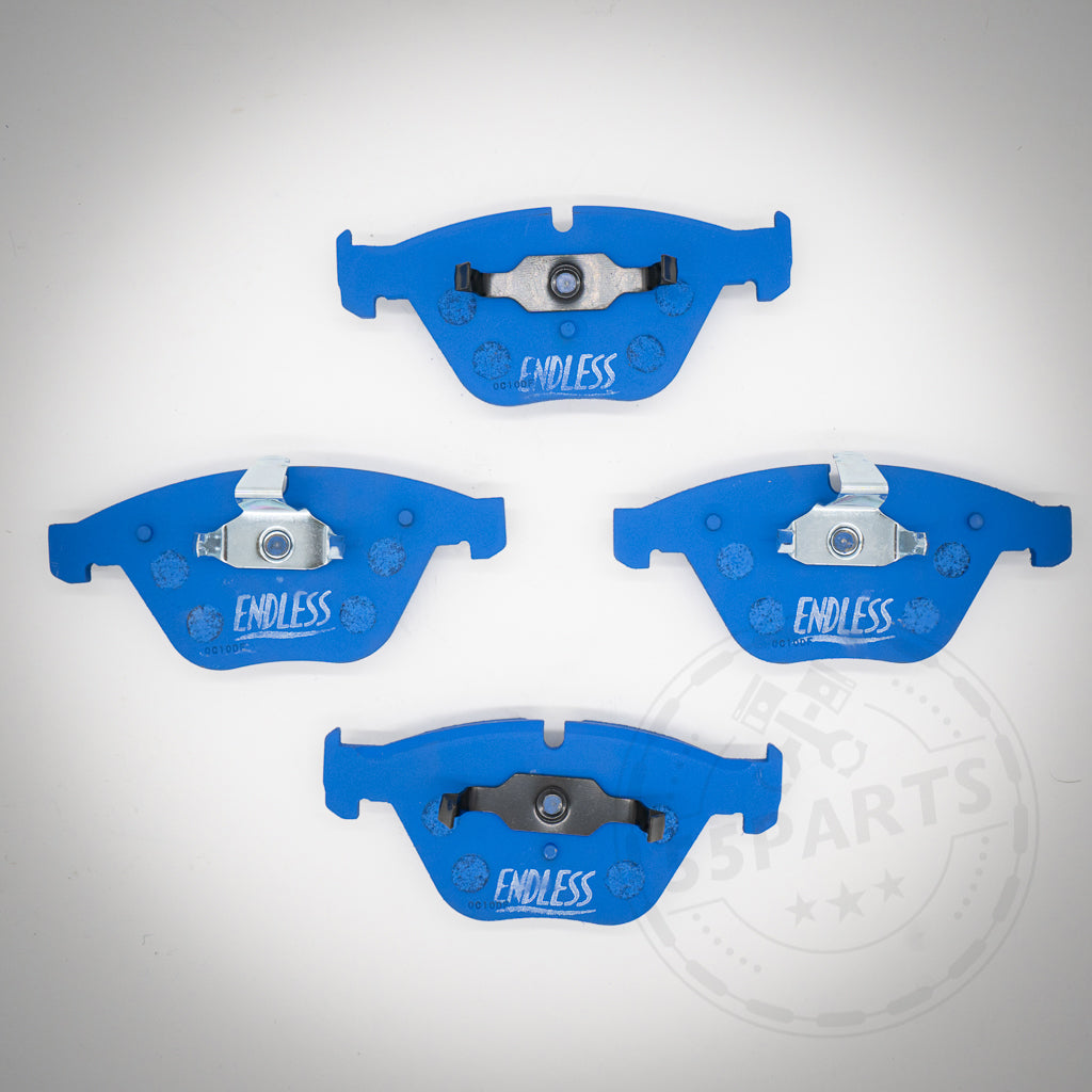 Vier blaue Endless Bremsbeläge für 1-Kolben Schwimmsattel, passend für BMW 1er M Coupe, M3, E9x 325d-335i, im Quadrat auf weißem Hintergrund angeordnet. Ideal für Rennstreckenfahrten.