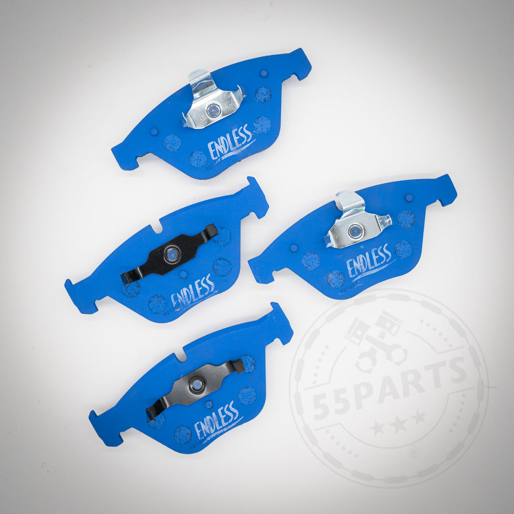 Vier blaue Endless Bremsbeläge für 1-Kolben Schwimmsattel, passend für BMW 1er M Coupe, M3 und E9x 325d-335i, sind auf weißem Untergrund angeordnet – ideal für Rennstrecke und als BMW Bremsen-Upgrade.