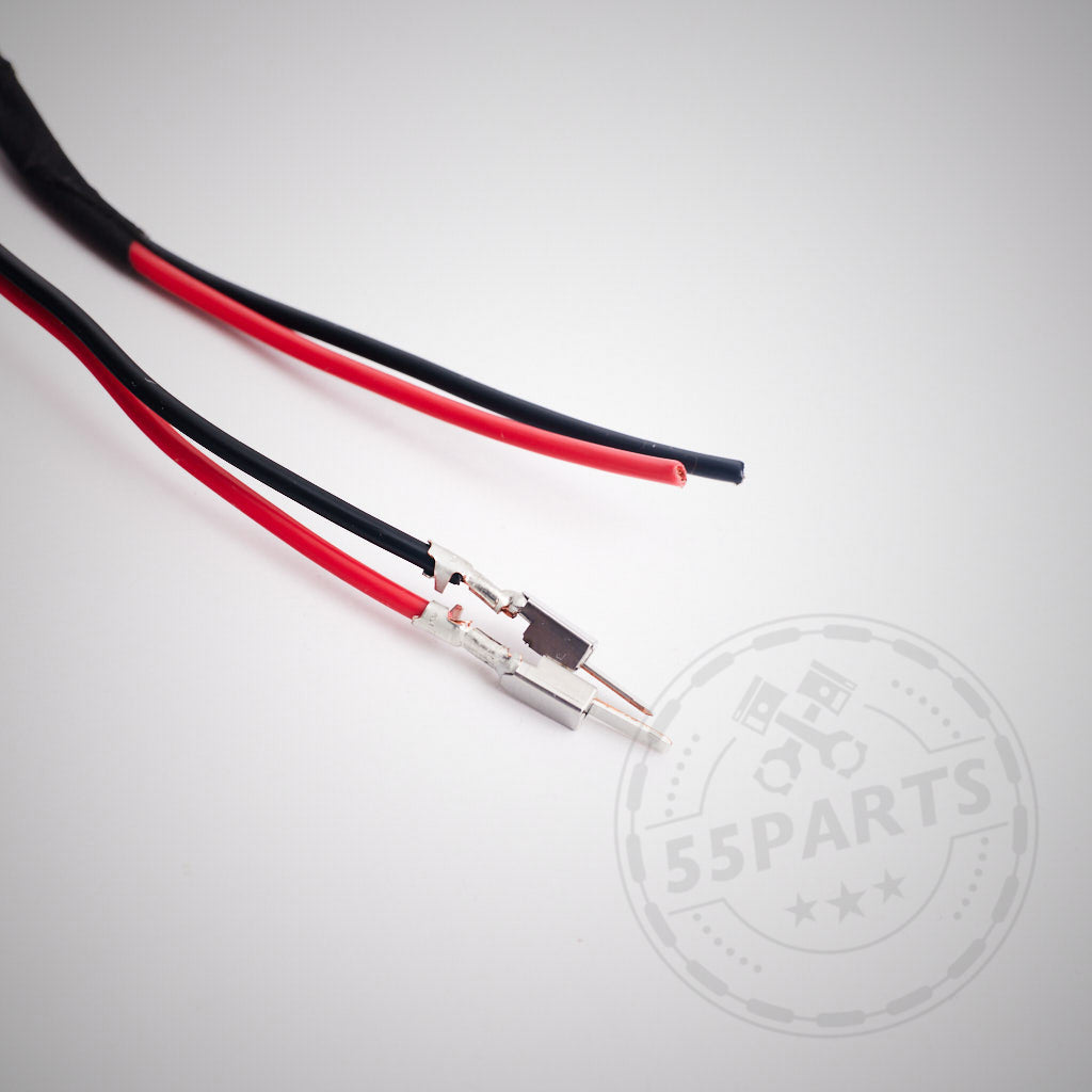 Zwei rote und schwarze Kabel mit Metallsteckern, auf Weiß fotografiert – perfekt als Teil des 55Parts Exclusive Erweiterungskits für Stahl-Seitenadapter mit Recaro Pole Position zur Verwendung mit elektronischen BMW-Sitzschienen.
