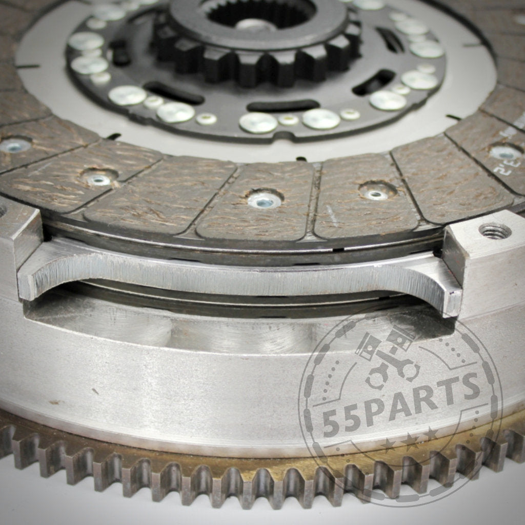 Nahaufnahme einer Metallkupplung mit sichtbaren Zahnrädern, Schrauben und dem 55Parts-Logo. Die 55Parts Exklusive Zweischeibenkupplung inkl. EMS ist ideal für BMW 135i, 335i(x) N54-Fahrer, die eine zuverlässige Kupplungslösung suchen.