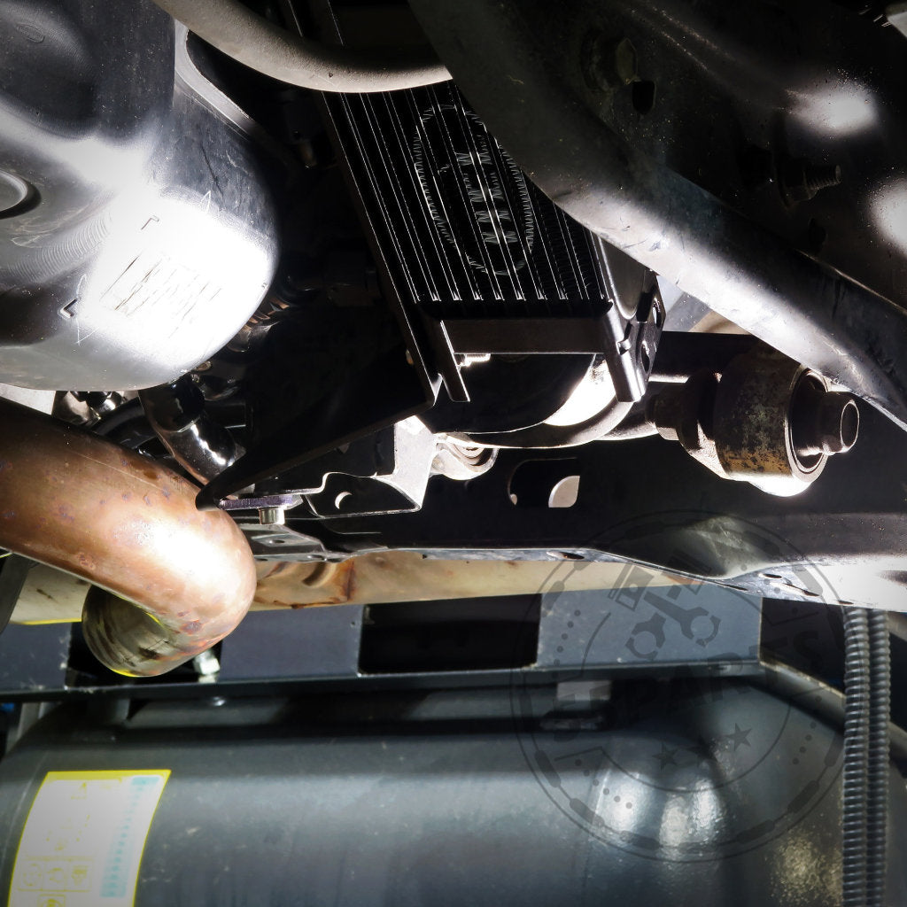 Ansicht eines Toyota GR Yaris-Fahrgestells mit dem HEL Performance Plug and Play Differential-Kühlungskit Hinterachse Special, abgebildet neben dem Auspuff und anderen Antriebsstrangkomponenten.