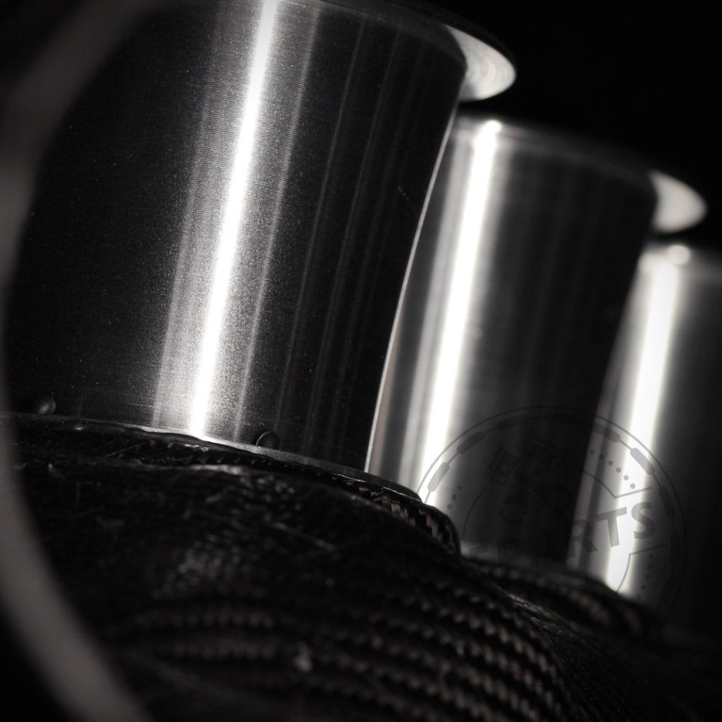 Drei Zylinder aus gebürstetem Metall, aus nächster Nähe vor einem dunklen Hintergrund aufgenommen, spiegeln die Präzision des 55Parts Special: Haimus Racing Carbon-Luftsammler passend für BMW E9x M3 wider.