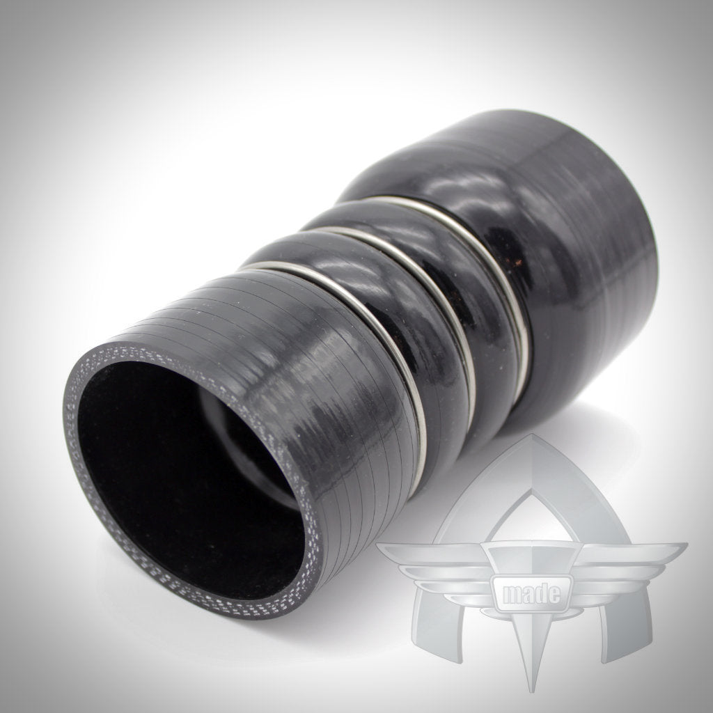 Das 55Parts-Exklusivangebot: ATmade Custom Silicone Hose Kit Ladeluftverrohrung von ATmade verfügt über einen schwarzen gerippten Silikonschlauch mit Metallringen auf einer weißen Oberfläche mit einem grauen Logo im Hintergrund.