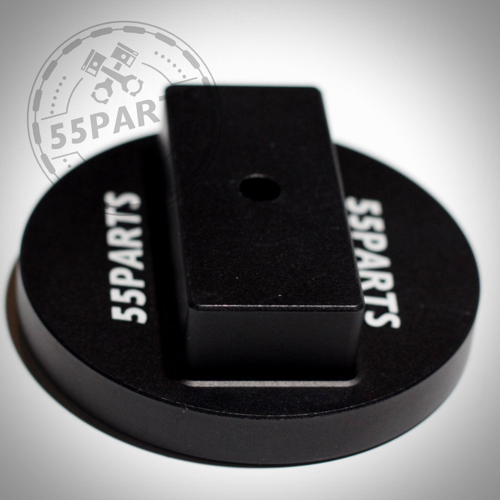 Der 55Parts Jackpad Wagenheberadapter Anhebehilfe Aufbockhilfe, eine runde schwarze CNC-gefräste Metallplatte mit einem zentralen Loch mit der Aufschrift Wagenheberaufnahme, ist passend für BMW geeignet und auf hellem Hintergrund abgebildet.