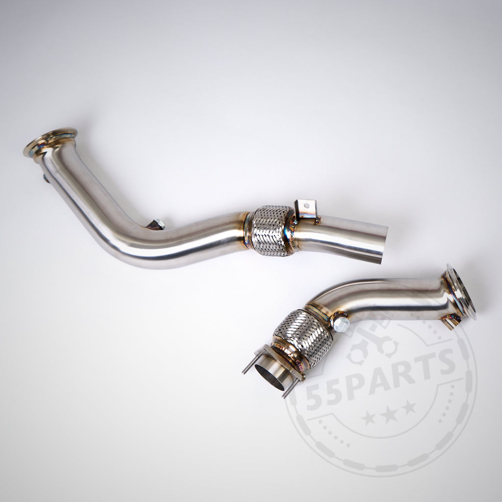 Zwei Catless Downpipes, entwickelt passend für BMW M2 Competition, M3 und M4 S55, mit Schweißverbindungen und Mesh-Flex-Abschnitten für optimale Ladedruckleistung – abgebildet auf weißem Hintergrund.