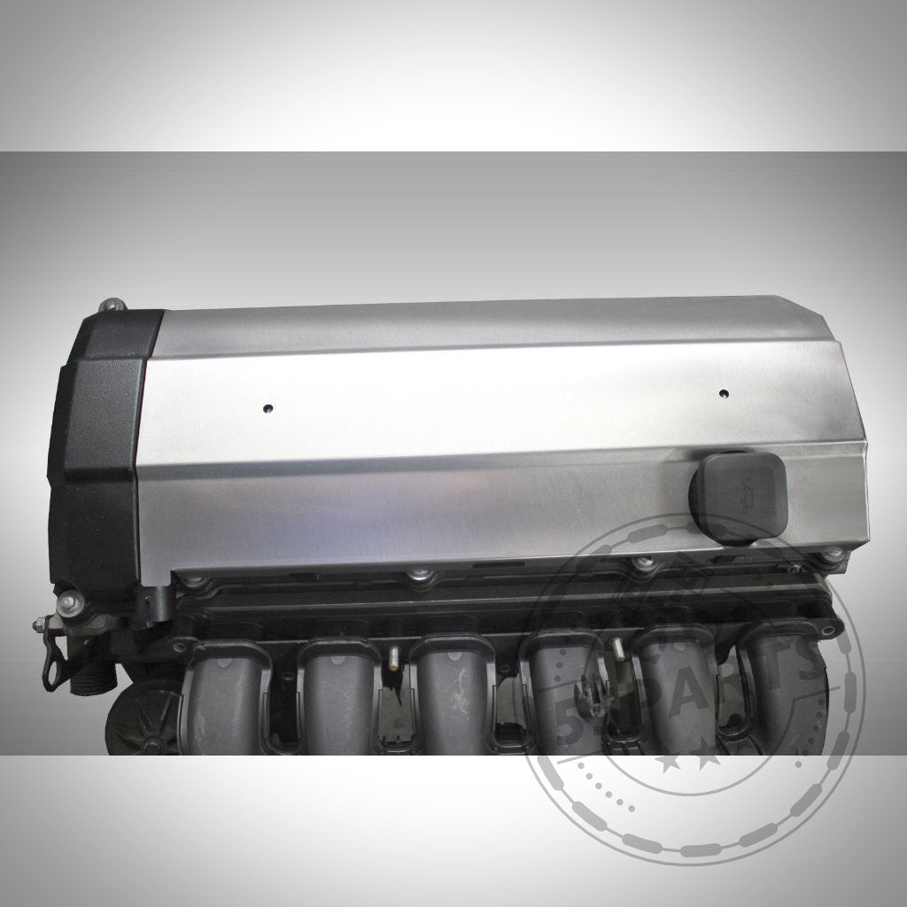 Nahaufnahme einer silber-schwarzen Automotorabdeckung mit sichtbarem Ansaugkrümmer darunter, mit dem 55Parts Hitzeschutzblech für Ventildeckel passend für BMW M50B25, M52B20 und B52B28.