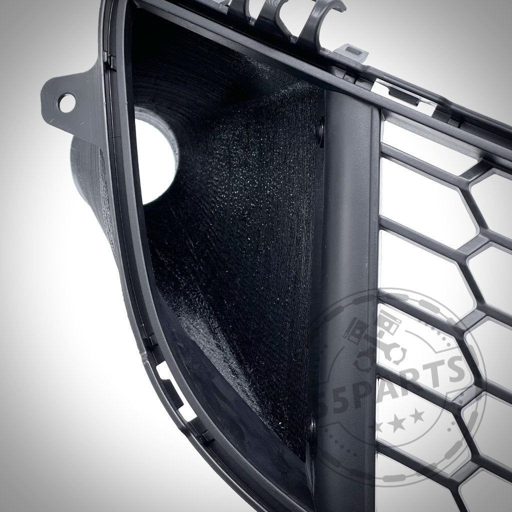 Nahaufnahme des 55Parts Exclusive Bremsbelüftungssets für den BMW 2er F22 mit M-Paket. Es zeigt einen schwarzen Wabengrill mit einer kreisförmigen Öffnung für verbesserte Bremskühlung und Leistung.