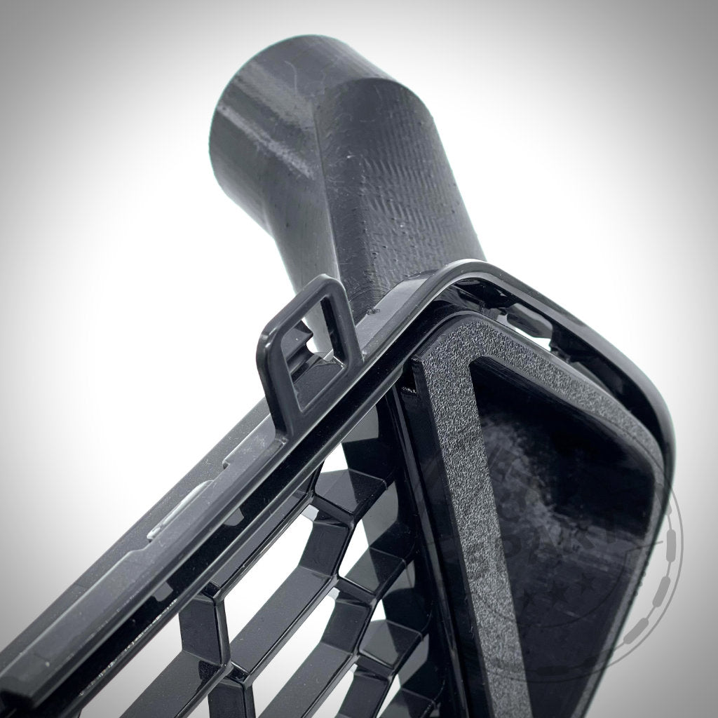 Nahaufnahme einer schwarzen Kunststoffentlüftung mit Hakenlasche und zylindrischem Aufsatz vom 55Parts Bremsbelüftungsset Bremskühlung, entwickelt passend für BMW M2 Competition und M2 CS S55 zur Unterstützung von Serienbremsen und Leistungssteigerungen.