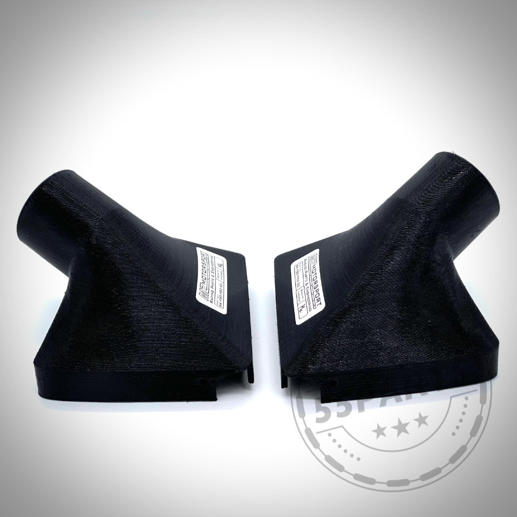 Zwei schwarze, abgewinkelte Kunststoffteile – Bremsbelüftungsset passend für BMW M3, M4 F80/F82/F8x S55 – stehen sich auf weißem Hintergrund gegenüber, ideal für optimale Rennstrecken-Leistungssteigerungen.