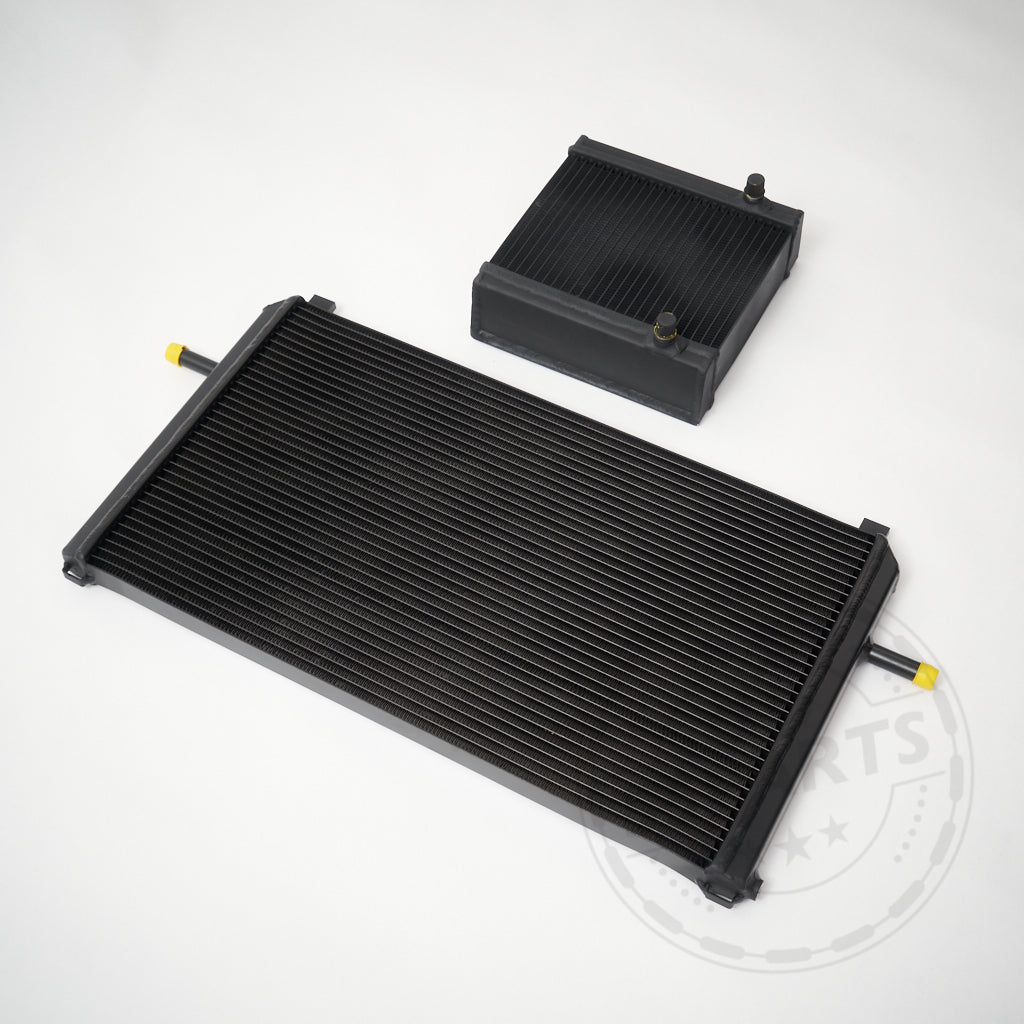 Auf einer weißen Fläche werden zwei schwarze 55Parts Ladeluftkühler-Upgrades (Wasser), kompatibel mit Mercedes Benz M133 AMG A45, CLA45 und GLA45 (W176, C117, X156), angezeigt.