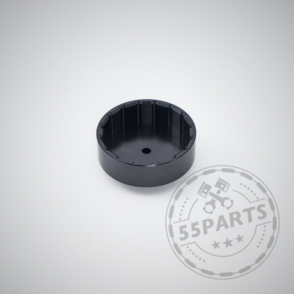Schwarzes, rundes Metallwerkzeug mit quadratischer Mitte auf hellem Hintergrund. Das 55Parts-Logo ist sichtbar. Das exklusive 55Parts Aluminium-Ölfilter-Montagewerkzeug passt passend für BMW N20-, N52-, N53-, N54-, N55- und S55-Motoren.