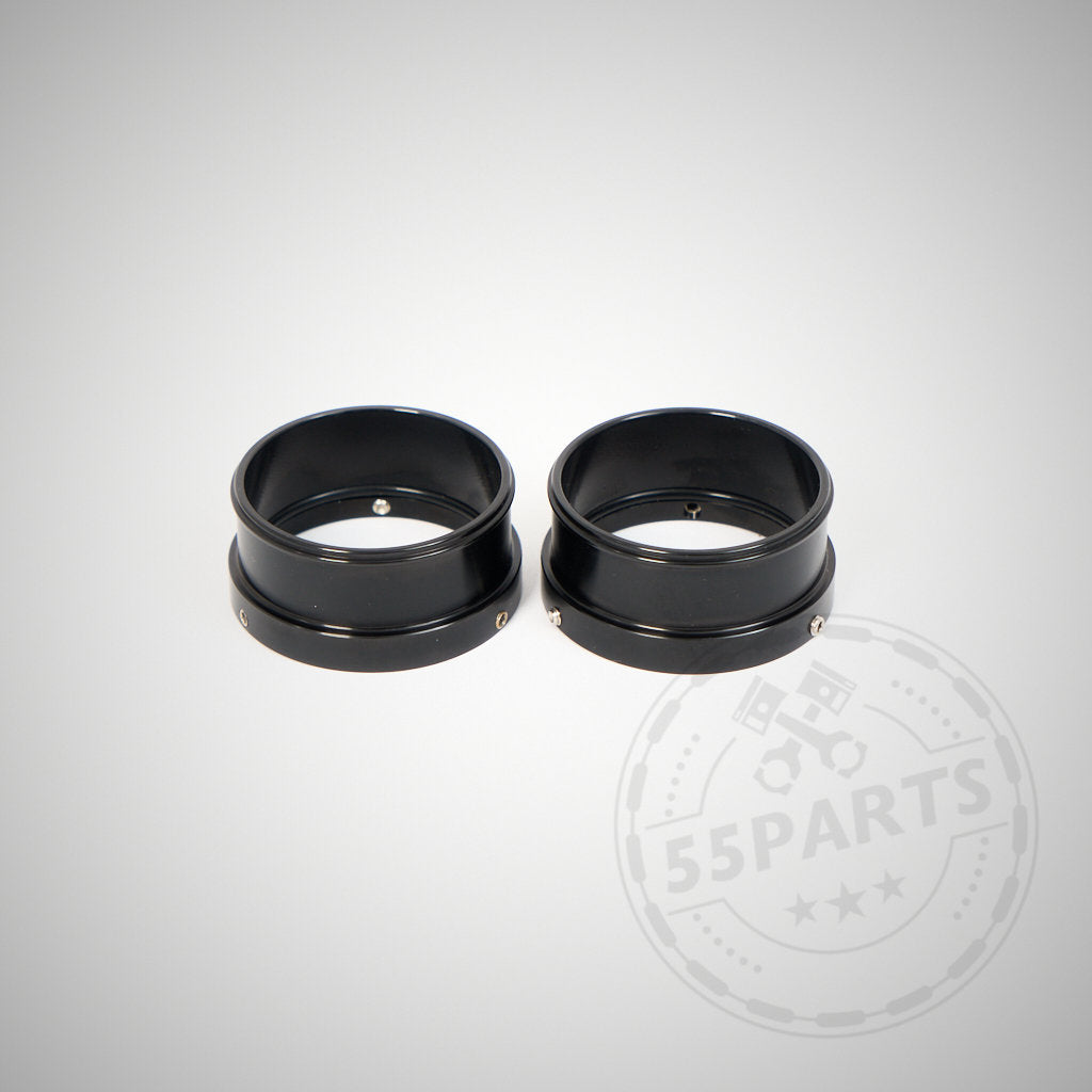 Zwei schwarze zylindrische Metallringe – 55Parts Adapter für Montage von 2&quot; Silikon Inlets auf 1,75&quot; Turbos, passend für BMW 135i, 1er M Coupe, 335i(x) N54 – liegen nebeneinander auf hellgrauem Hintergrund.