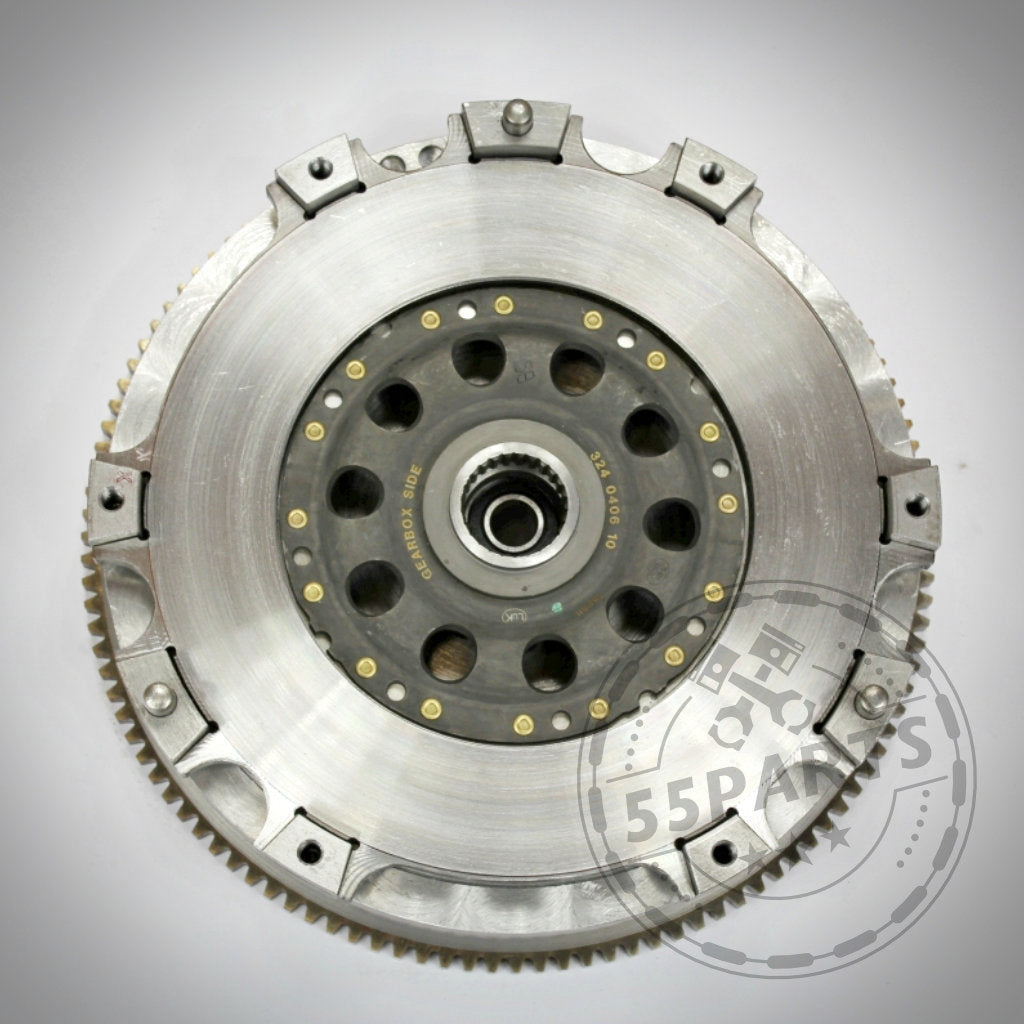 Eine Nahaufnahme der 55Parts Exclusive Zweischeibenkupplung inkl. EMS passend für BMW M135i, M235i, 335i(x) und 1er M zeigt sichtbare Zahnräder und Schraubenlöcher auf robustem C45-Stahl – ideal für eine Kupplungslösung.