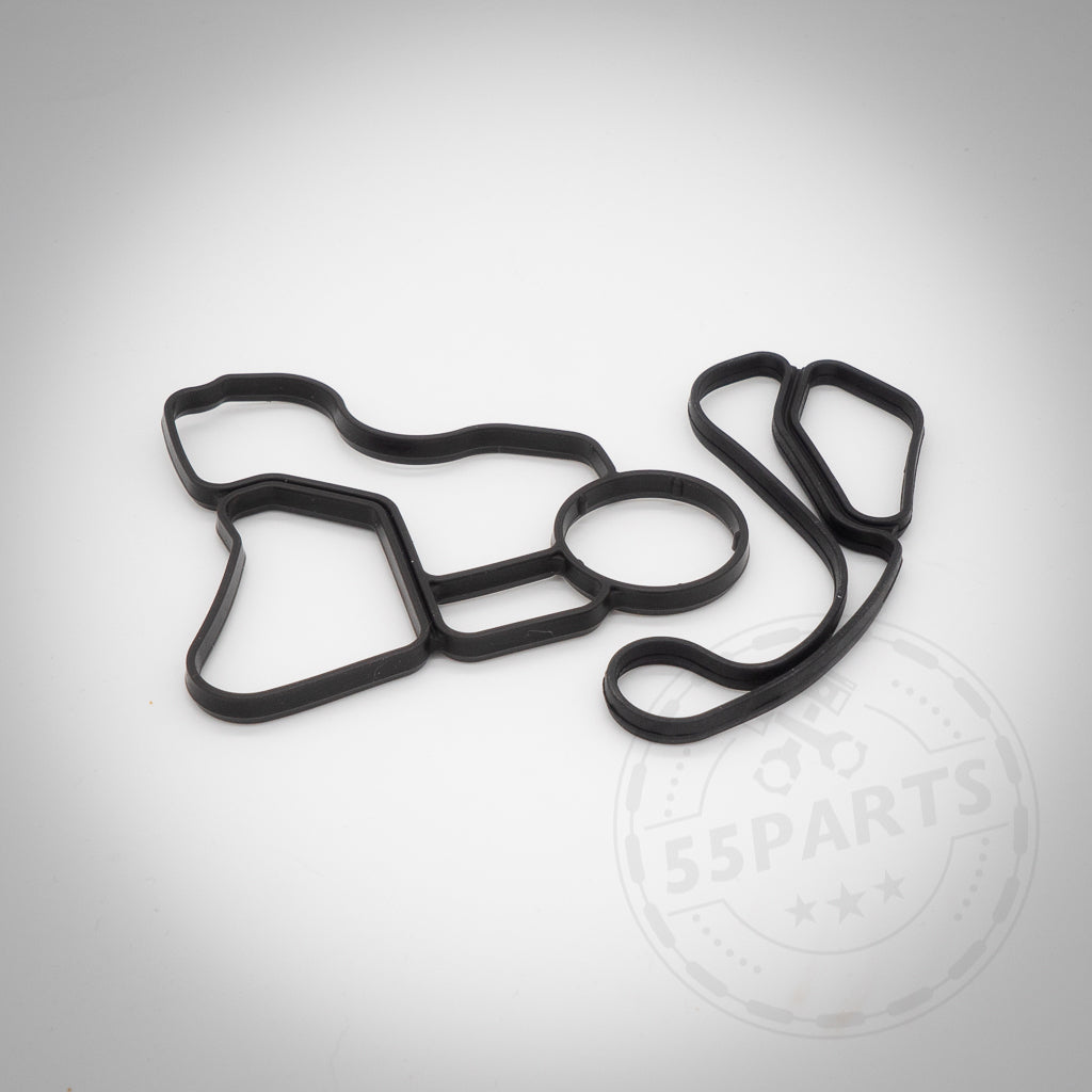 Die 55Parts Dichtung(en) Thermostatgehäuse für N52, N53, N54, N55 und S55 Motoren ist eine schwarze Gummi-Automobildichtung mit unregelmäßiger Form, die auf einem schlichten weißen Hintergrund angezeigt wird.