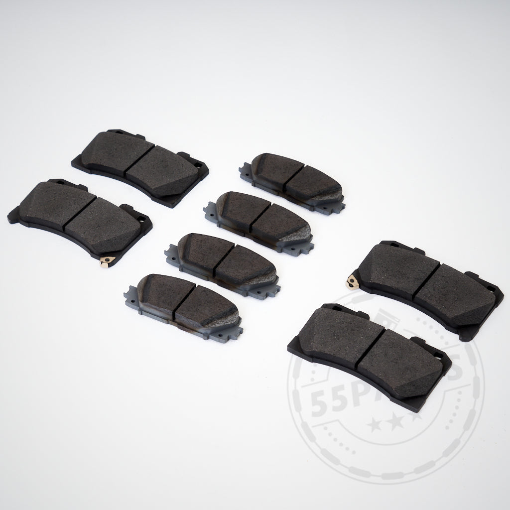 Acht schwarze 55Parts Original-Bremsbeläge passend für Toyota Yaris GR sind auf einer weißen Fläche angeordnet, ideal als Verschleißteile.