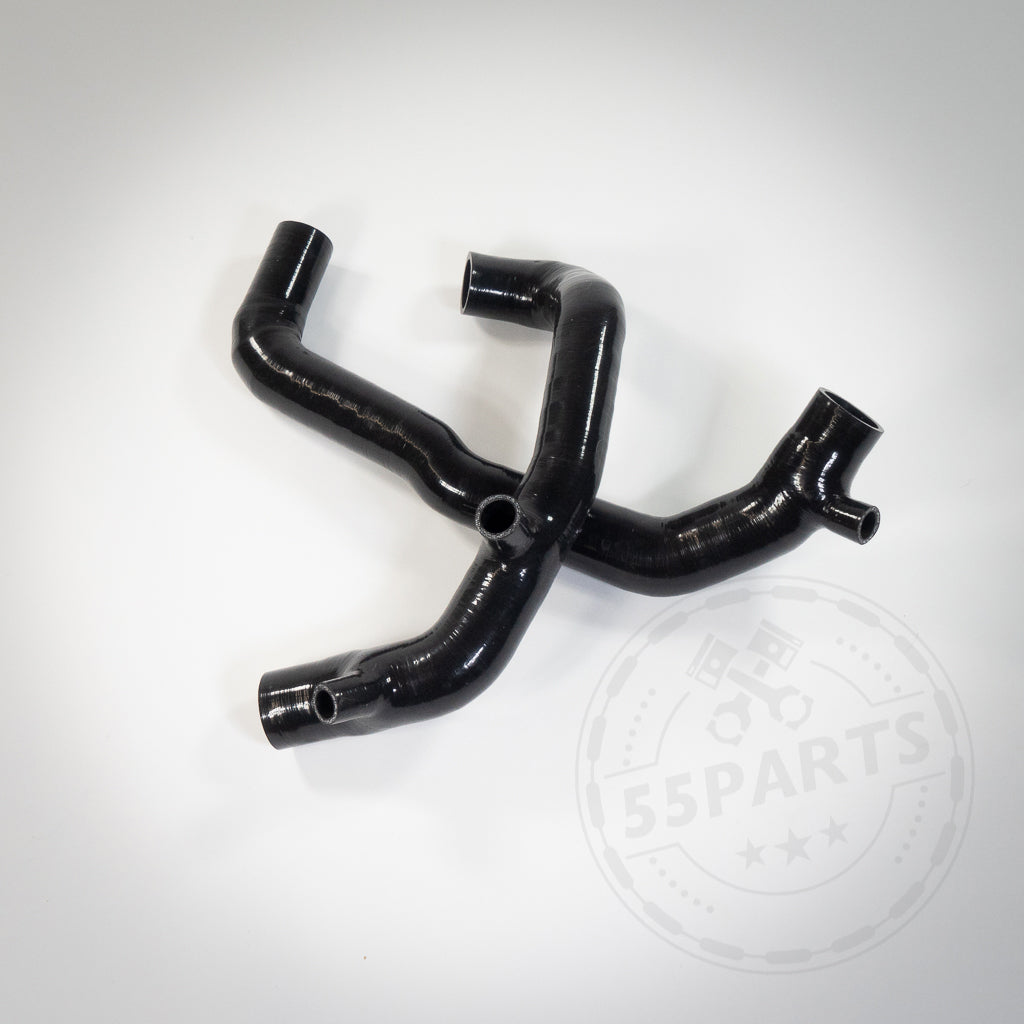 Zwei schwarze Silikon-Upgrade-Inlets-Ansaugrohre, konzipiert passend für BMW 135i, 1er M Coupé und 335i(x) N54, sind X-förmig auf weißem Untergrund angeordnet.