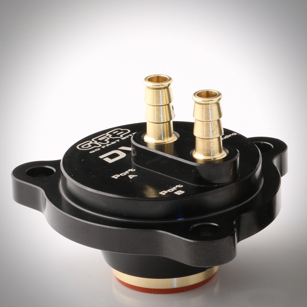 GFB DV+ - Verstärktes Schubumluftventil passend für Mini R5x Cooper S, JCW John Cooper Works N18: Schwarzes und goldenes elektronisches Bauteil mit zwei Düsen und beschrifteten Anschlüssen für Ladedruckregelung auf weißem Hintergrund.