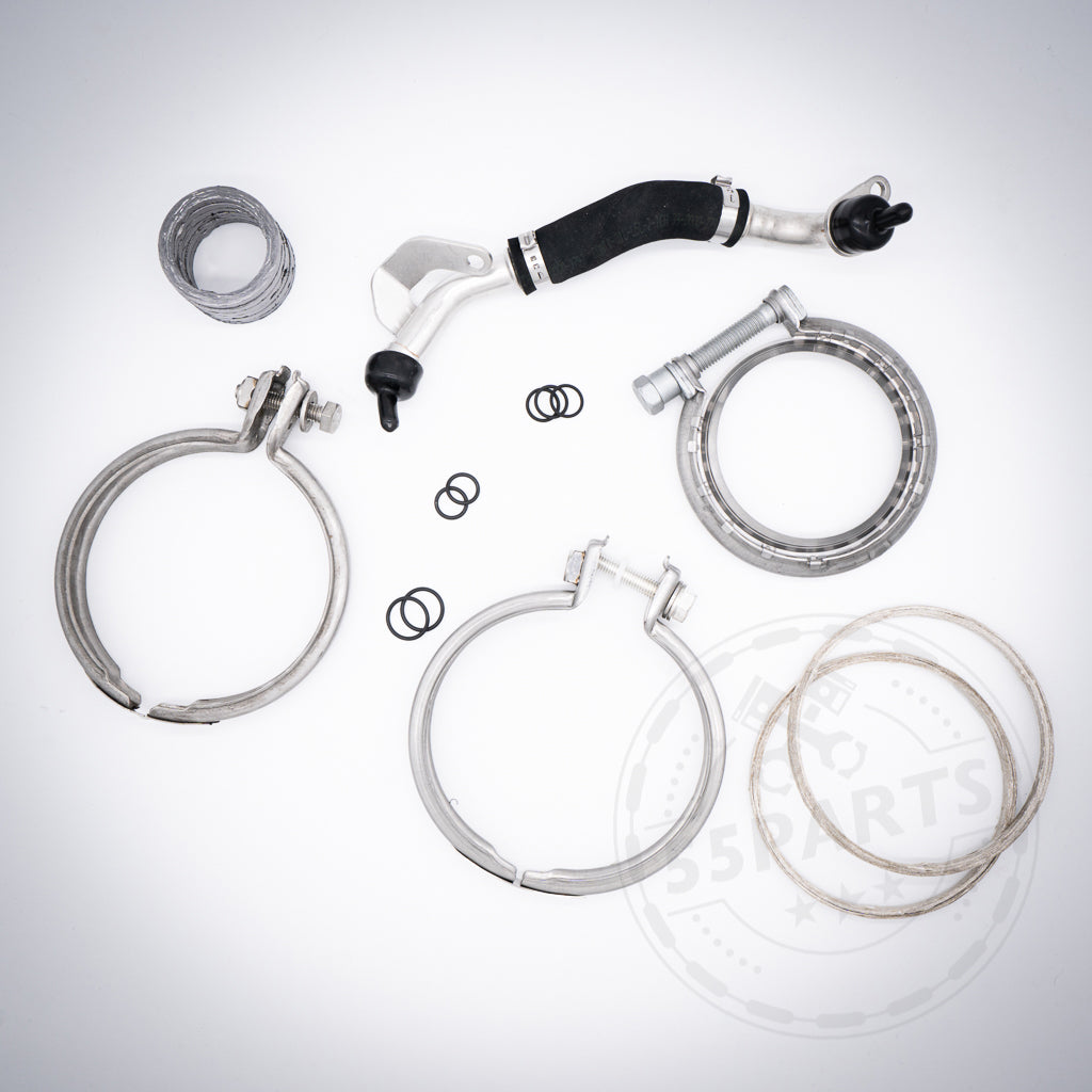 Verschiedene Metallklemmen, Schläuche und Gummi-O-Ringe aus dem 55Parts Turbolader-Einbauset passend für BMW (M)135i, M235(x)i, 335(x)i, 435(x)i, M2 N55 E- & F Serie, angeordnet auf weißem Hintergrund.