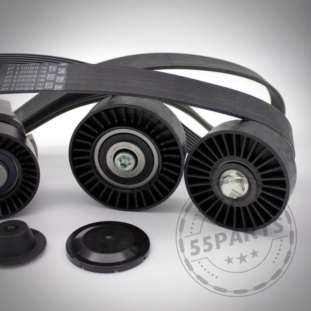 Nahaufnahme des 55Parts Riementrieb-Komplettkit-Reparatursatzes passend für BMW 135i, 1er M Coupé und 335i(x) N54. Zu sehen sind drei schwarze Umlenkrollen mit einem Keilrippenriemen und zwei schwarzen Abdeckkappen.