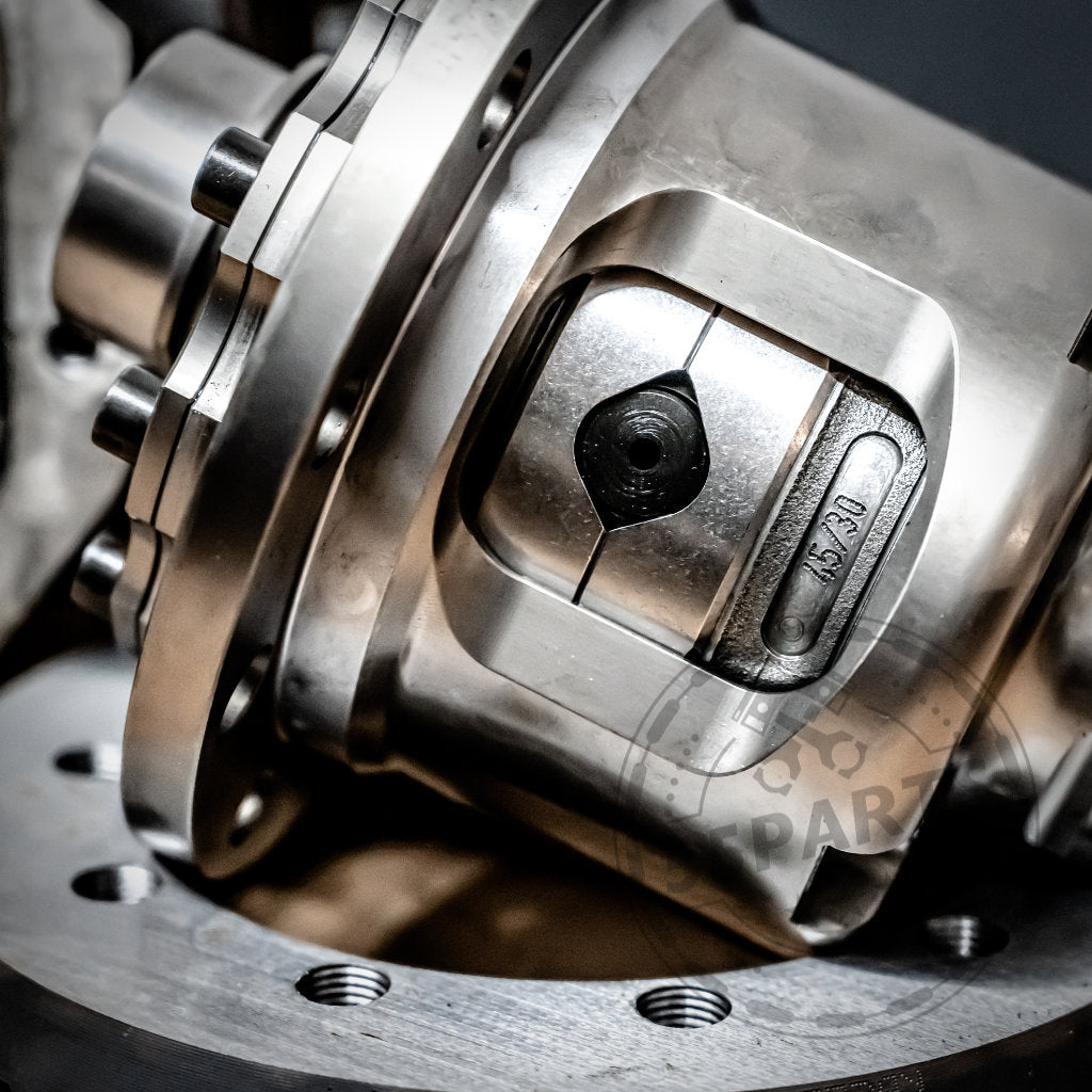 Nahaufnahme eines glänzenden Metallmaschinenteils mit Schrauben und einem Zylinder, mit dem 55Parts Special Mechanische Drexler Lamellensperrdifferential & Westwood Performance für verbesserte BMW-Leistung.