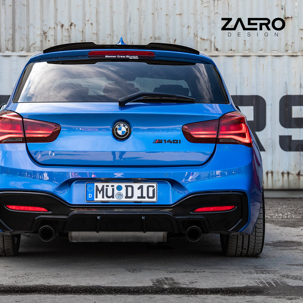 Ein blauer BMW M140i mit glanzschwarzen Carbon-Anbauteilen und einem ZAERO Evo-1 Diffusor passend für BMW M135i M140i F2x steht von hinten betrachtet vor einer weißen Wand, darüber ein ZAERO-Logo.