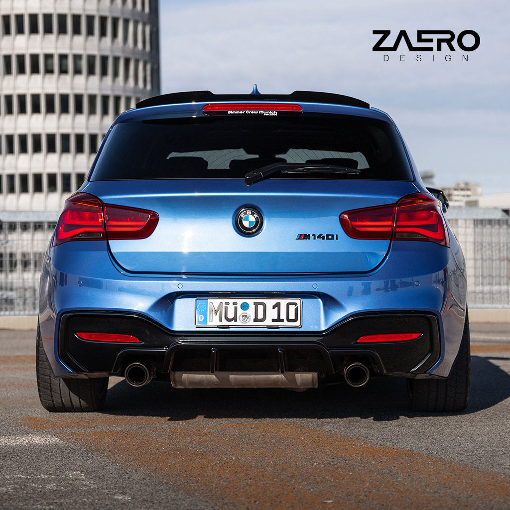 Ein im Freien geparkter blauer BMW M140i ist von hinten betrachtet mit einem ZAERO Evo-1 Diffusor passend für BMW M135i M140i F2x ausgestattet, in der Ecke ist das „ZAERO DESIGN“-Logo sichtbar.