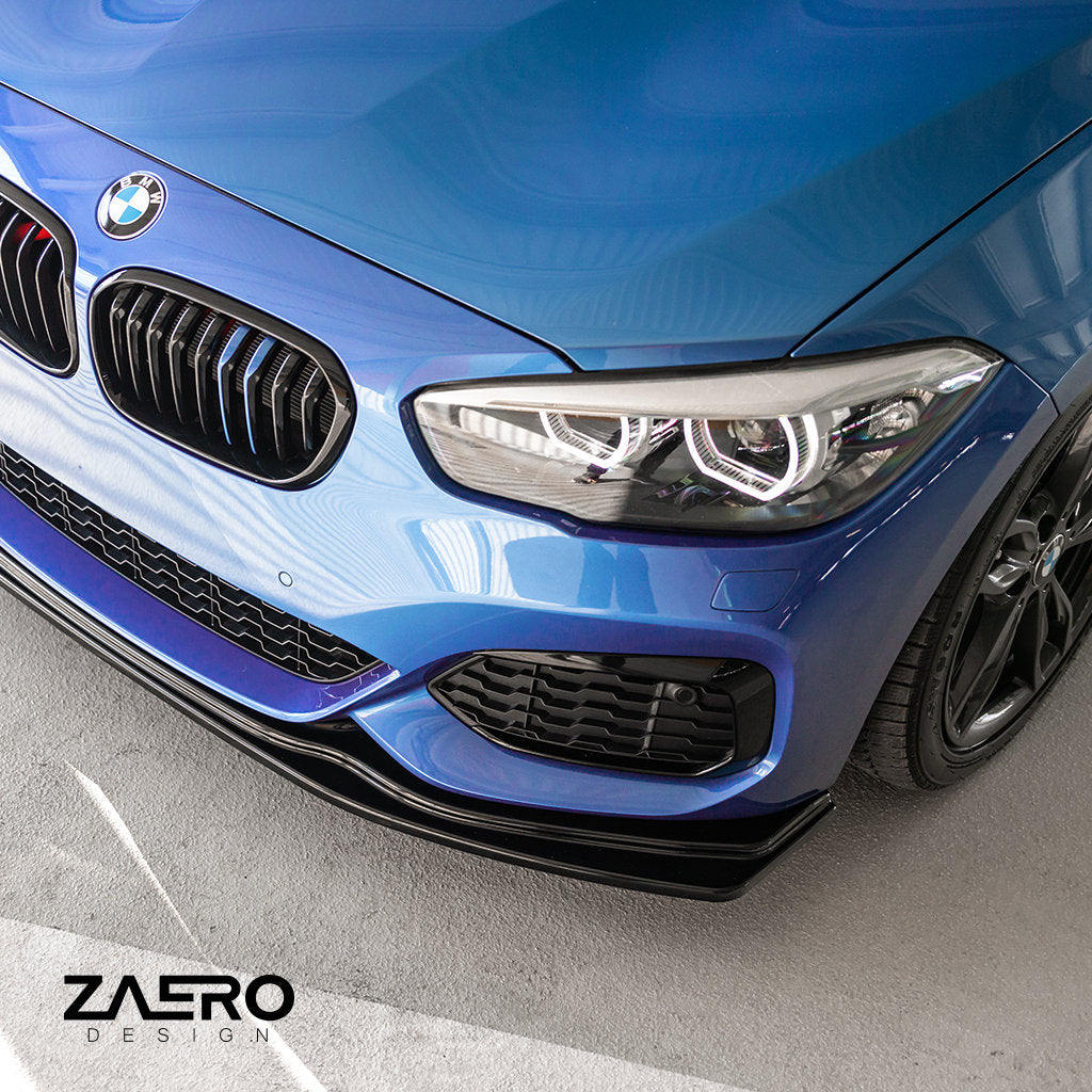 Nahaufnahme der Frontstoßstange und des Scheinwerfers eines blauen BMW F2x mit ZAERO-Branding und dem ZAERO Evo-1 Frontspoiler passend für BMW F2x in Glanz Schwarz.