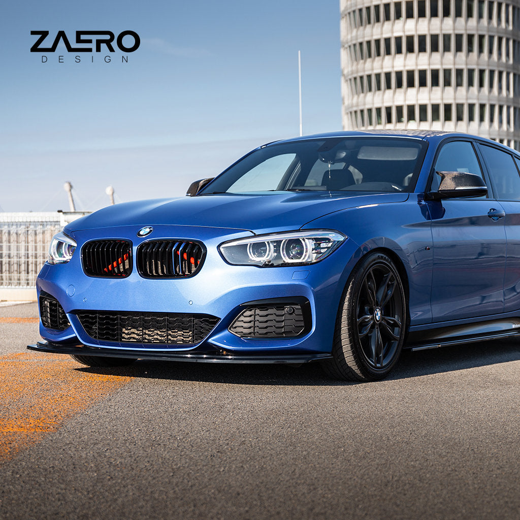 Vor einem modernen Rundgebäude mit dem Zaero Design Logo parkt ein blauer BMW F2x mit einem ZAERO Evo-1 Frontspoiler von ZAERO in Glanz Schwarz.