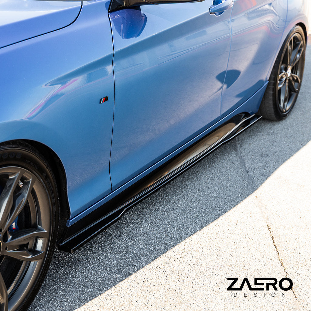 Nahaufnahme eines blauen BMW F2x mit ZAERO Evo-1-Seitenschwellern passend für BMW F2x und M-Paket, auf dem Bürgersteig geparkt; Zaero-Logo sichtbar.