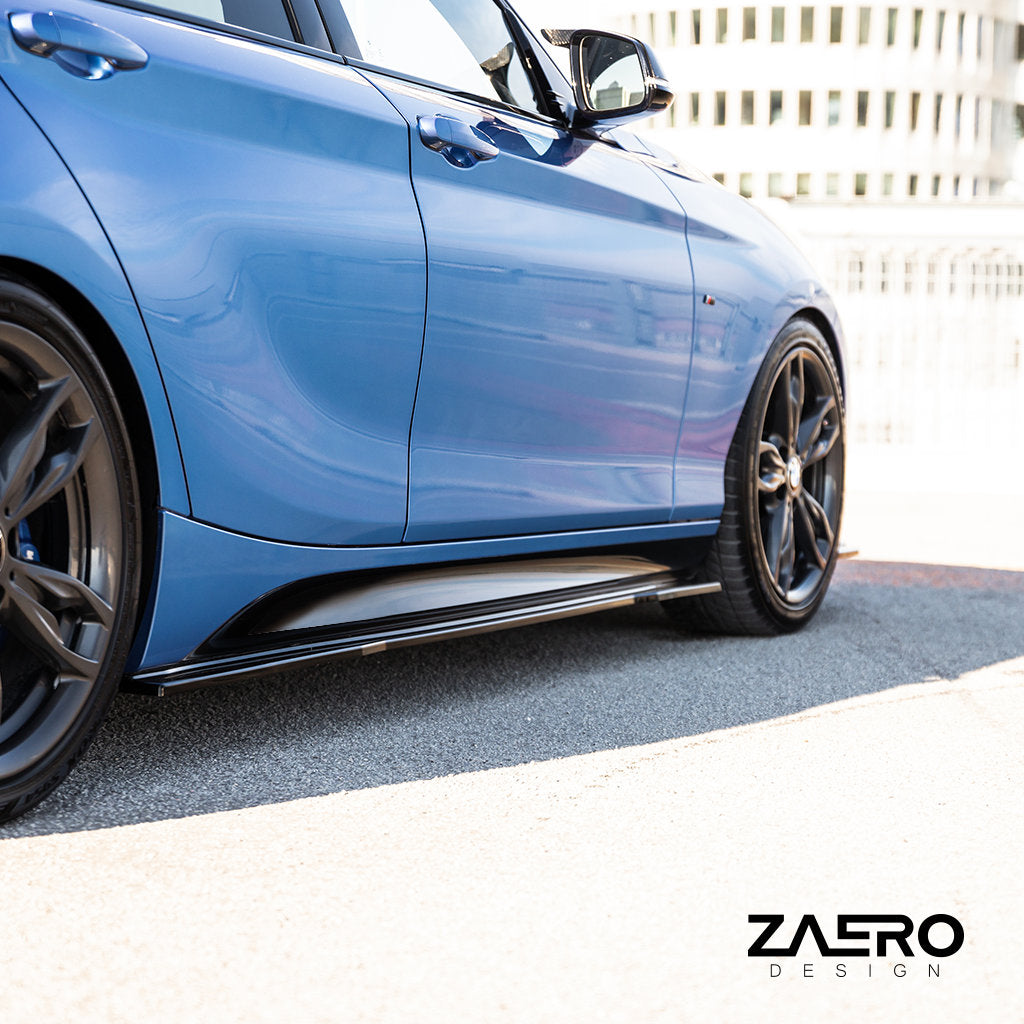 Nahaufnahme der Seitenansicht eines blauen Sportwagens mit glänzend schwarzen Felgen, ZAERO Evo-1-Seitenschwellern passend für BMW F2x und dem ZAERO-Logo in der Ecke.